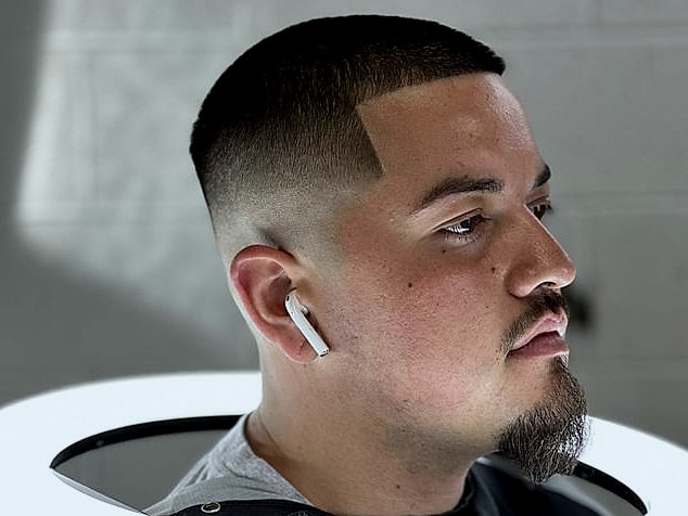 Perfil de un cliente con fade corto, la línea del frente marcada en escuadra y candado.